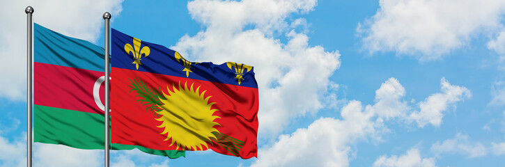 Azerbaijan and Guadeloupe flag waving in the wind against white cloudy blue sky together. Diplomacy concept, international relations.