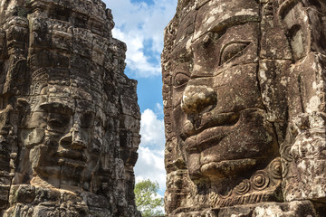 Fototapeta premium Faces carved in stone in Bayon temple towers, Angkor Wat complex, Cambodia, Siem Reap