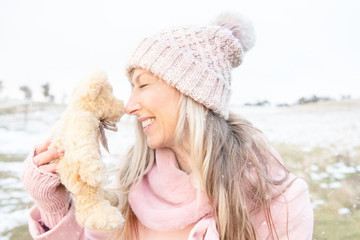 Smiling woman nose to nose with teddy bear