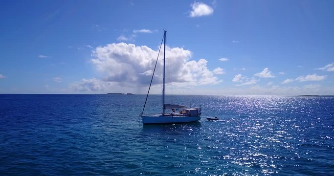 Arc shot of luxurious sail boat off the coast of luscious island in the Maldives