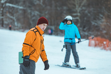 Fototapeta na wymiar young man riding snowboard by winter hill