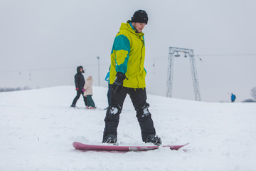 man snowboarding down by hill