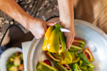 A woman cuts a paprika with a knife