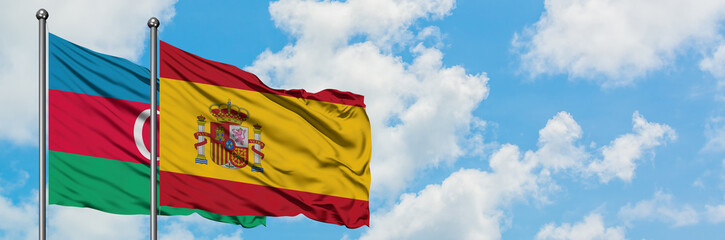 Fototapeta premium Azerbaijan and Spain flag waving in the wind against white cloudy blue sky together. Diplomacy concept, international relations.