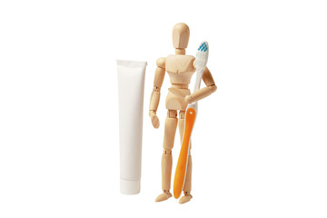 Oral hygiene and dental care. Wooden man holds toothbrush and toothpaste.