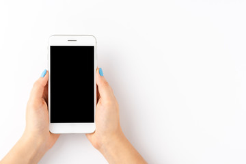 Woman’s hands using mobile phone with empty screen isolated on white background. Top view