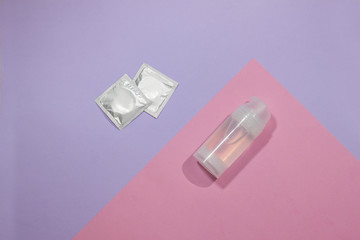  Intimate lubricant and condoms on a colored background. Comfortable sex, protected sex.