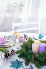 Fototapeta na wymiar Place table setting for Christmas white table with purple decor elements and green wreath Christmas tree