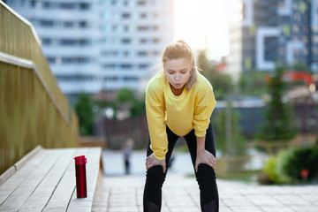 Sport woman in yellow is training in an urban environment.