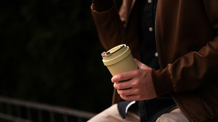 Fototapeta na wymiar A young guy holds eco coffee cup. Zero waste concept.