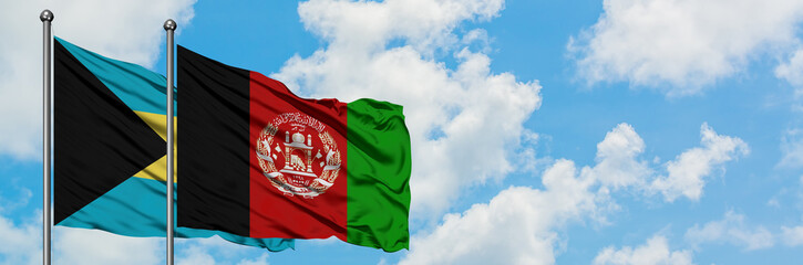 Bahamas and Afghanistan flag waving in the wind against white cloudy blue sky together. Diplomacy concept, international relations.