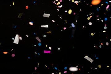 colorful party confetti flying in front of black