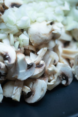 сooking onions and mushrooms on wok pan