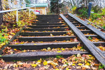 Wooden old staircase in the park equipped with a descent for the disabled and strollers. Autumn,...