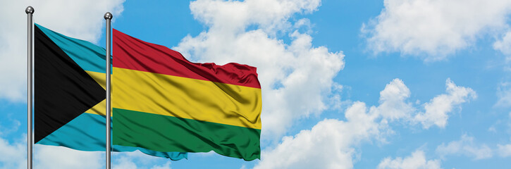 Obraz premium Bahamas and Bolivia flag waving in the wind against white cloudy blue sky together. Diplomacy concept, international relations.