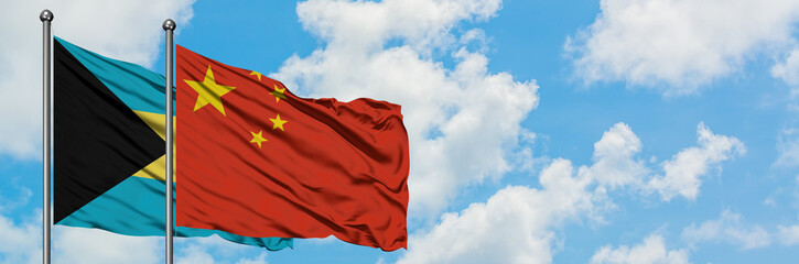 Bahamas and China flag waving in the wind against white cloudy blue sky together. Diplomacy concept, international relations.