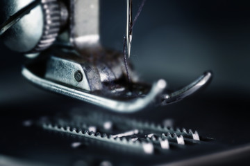 Needle plate, presser foot and feed dog transporter of a sewing machine as very close macro shot,...