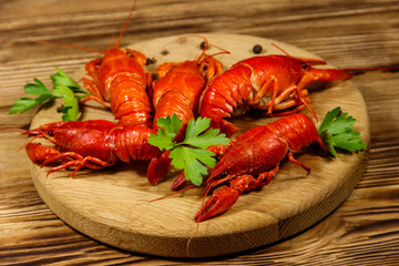 Boiled crayfish on cutting board on wooden table