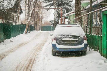 Dirty car in the snow on a village street
