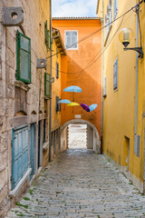 Fototapeta na wymiar Croatia, Istria, beautiful old cobbled street, traditional houses and umbrellas decorations in the old historical town of Labin