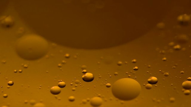 Abstract colorful background. Foam of Soap with Bubbles macro shot. Closeup bubbles in water. Oil drops on a water surface abstract background. Golden yellow bubble.Yellow water bubbles wallpaper. 4k 