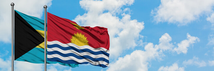 Bahamas and Kiribati flag waving in the wind against white cloudy blue sky together. Diplomacy concept, international relations.