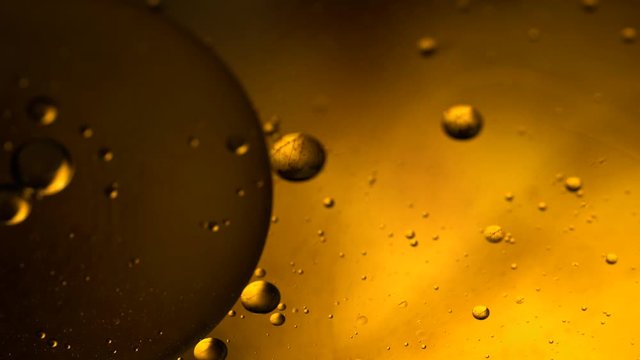 Abstract colorful background. Foam of Soap with Bubbles macro shot. Closeup bubbles in water. Oil drops on a water surface abstract background. Golden yellow bubble.Yellow water bubbles wallpaper. 4k 
