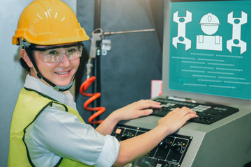 Asian female engineer factory inspection computer control with robot ai machine assist production engineer in industry She wears a helmet female working metalwork control in industrial factory 