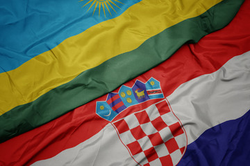 waving colorful flag of croatia and national flag of rwanda.