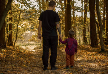 Fototapeta premium father with son in the autumn forest looks into the distance