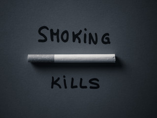 Cigarette isolated on red background with text Smoking kills