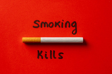 Cigarette isolated on red background with text Smoking kills