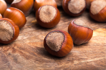 close up of hazelnuts on wooden table .