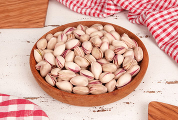 Pistachios on wooden board and white vintage background 