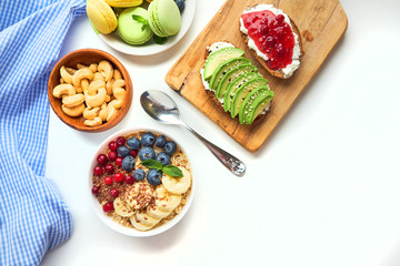 breakfast top view isolate white background. oatmeal with berries, toasts on a wooden tray, nuts, coffee