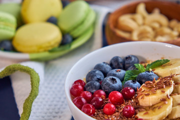 breakfast top view black background. oatmeal with berries, toasts on a wooden tray, nuts, coffee