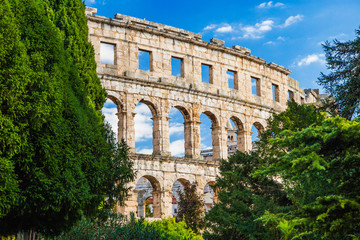 Obraz premium Ancient Roman Arena in Pula, Istria, Croatia, historic amphitheater landscape view through the trees in park