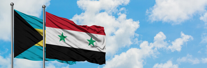 Bahamas and Syria flag waving in the wind against white cloudy blue sky together. Diplomacy...