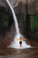 Fototapeta na wymiar Women playing in the water at Tham Phra Waterfall in Bueng Kan, Thailand.