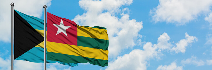 Fototapeta na wymiar Bahamas and Togo flag waving in the wind against white cloudy blue sky together. Diplomacy concept, international relations.