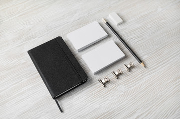 Blank stationery template on light wooden background. Black notebook, business cards, pencil and eraser. Branding mock up.