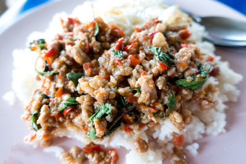 Salted pork with chili & Basil leaves in black plate on wood. Select focus.