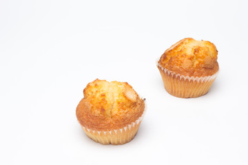 Magdalenas, bollería industrial, sobre fondo blanco; pastelitos para ser comidos en los desayunos y en las meriendas, muchas calorías, mucha azúcar, comida poco saludable