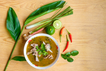 Spicy duck soup in white cup on wooden table