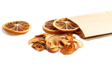 Organic homemade dry fruit chips in a paper eco pack on a white background. Healthy vegan snack of apples and orange. The concept of proper nutrition, organic and vegetarian food. Top view, copy space