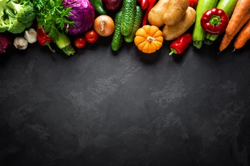 Poster Culinary background with fresh raw vegetables on a black kitchen table, healthy vegetarian food concept, flat lay composition, top view © Sea Wave