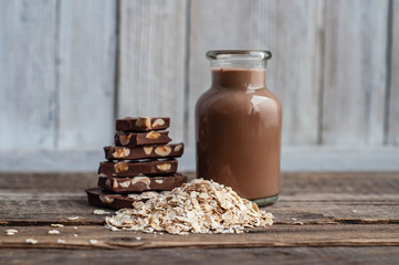 chocolate oatmeal milk with chocolate chips and oatmeal on a wooden table