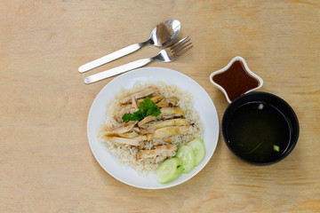 Steamed chicken with rice in white plate on the wood table with space for text.
