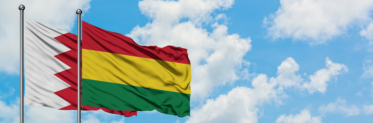 Bahrain and Bolivia flag waving in the wind against white cloudy blue sky together. Diplomacy concept, international relations.