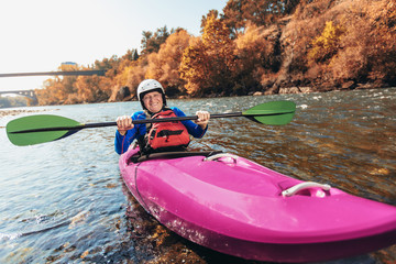 Active senior man paddling kayak. Gray hair man enjoy river kayaking.